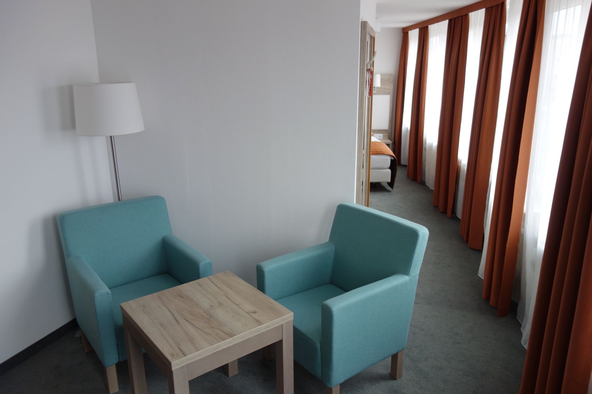 A hotel room with two chairs and a table