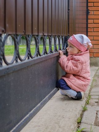 Young Kid On the Iron Gate — Iron Fences in Garden Grove