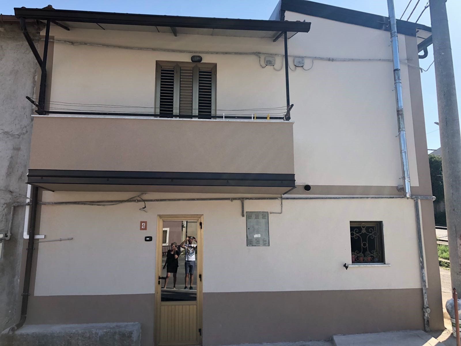 Un edificio bianco con un balcone e una porta