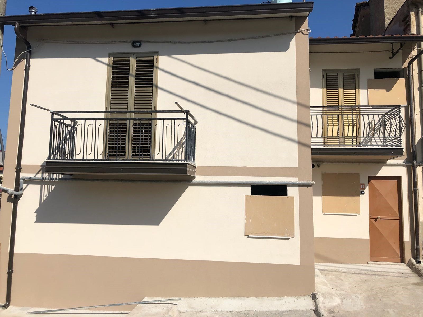 Una casa con balcone e persiane alle finestre