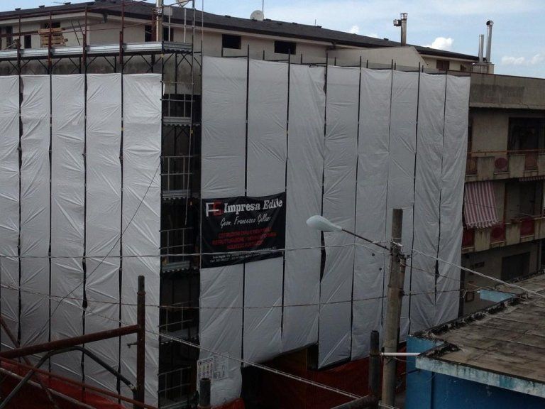 Un edificio con impalcature e un cartello che dice f. impresa elite