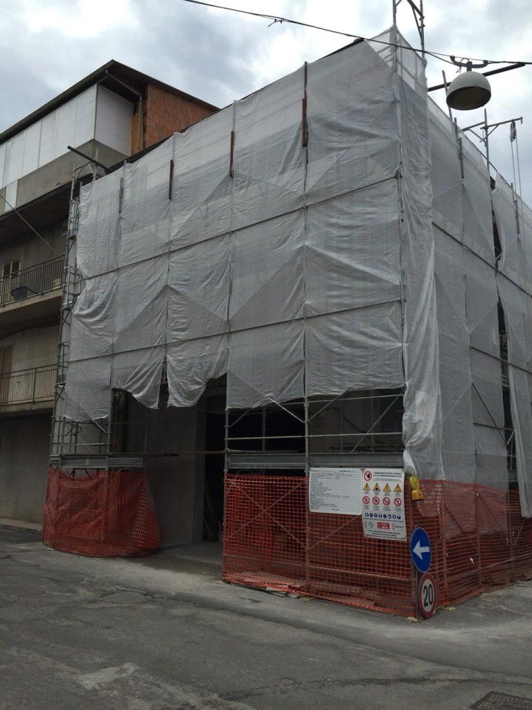 Un edificio è coperto da impalcature e teloni.