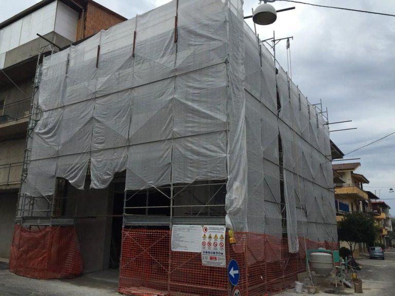 Un edificio in costruzione con impalcature ai lati.
