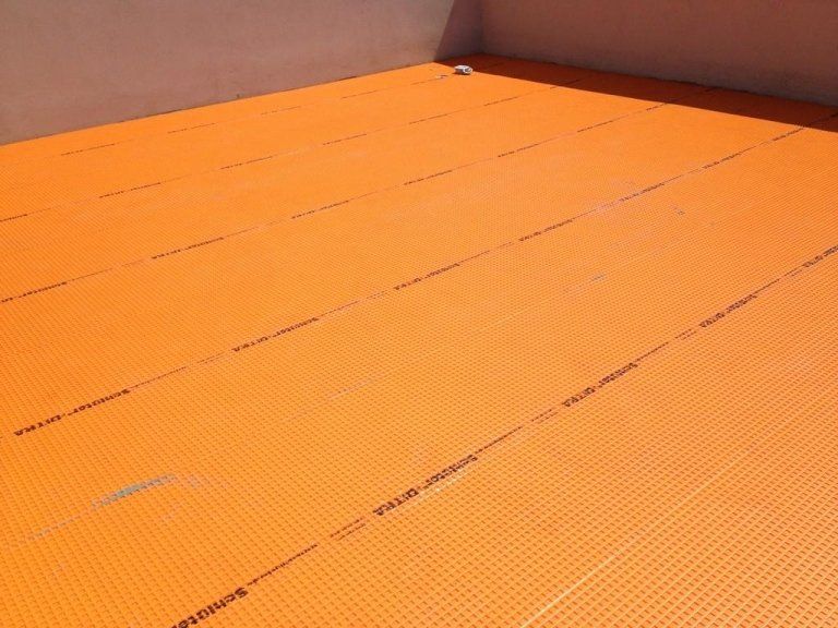 Primo piano di uno zerbino arancione sul pavimento di una stanza.