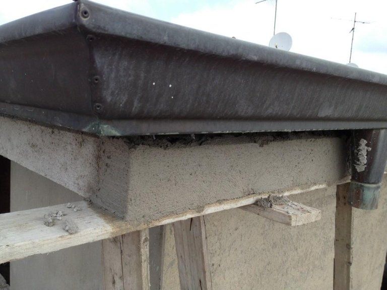 Primo piano di una grondaia sul lato di un edificio.