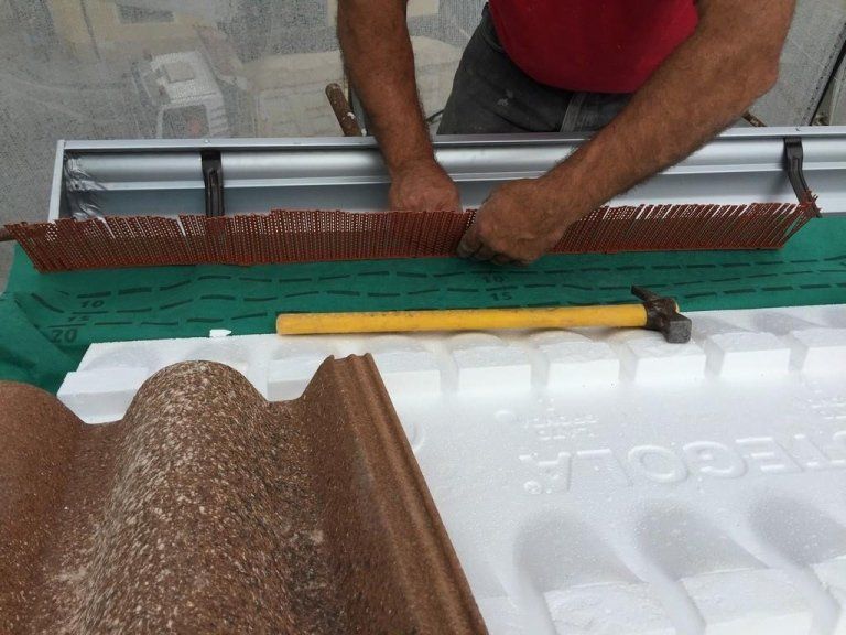 Un uomo sta lavorando su un pezzo di polistirolo con un martello