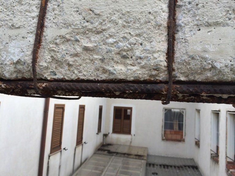 Un edificio con un muro di cemento e poche finestre