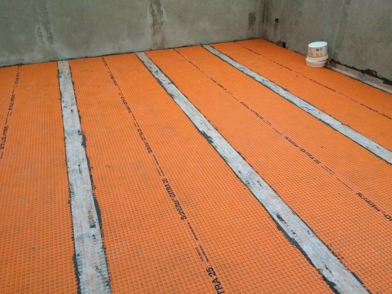Una stanza con un muro di cemento e un pavimento con la scritta 