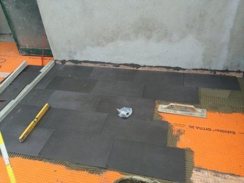 Un pavimento in piastrelle nere viene installato in una stanza