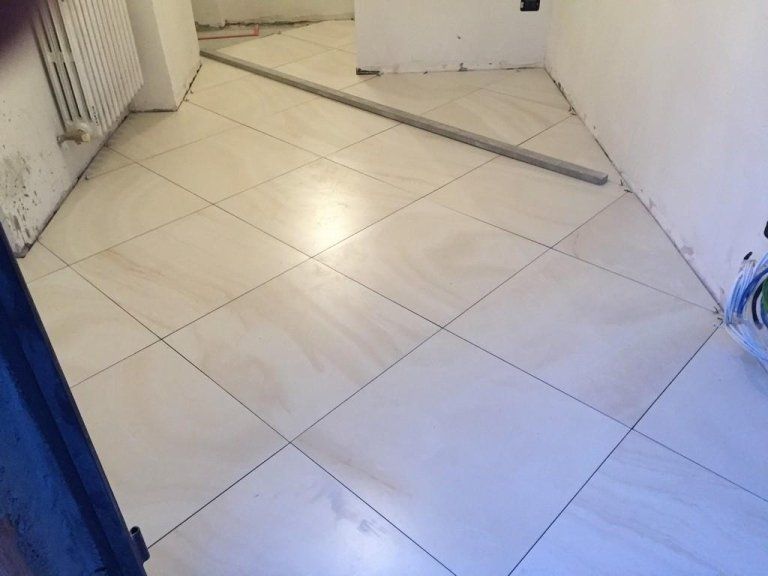 Una stanza con pavimento piastrellato e termosifone