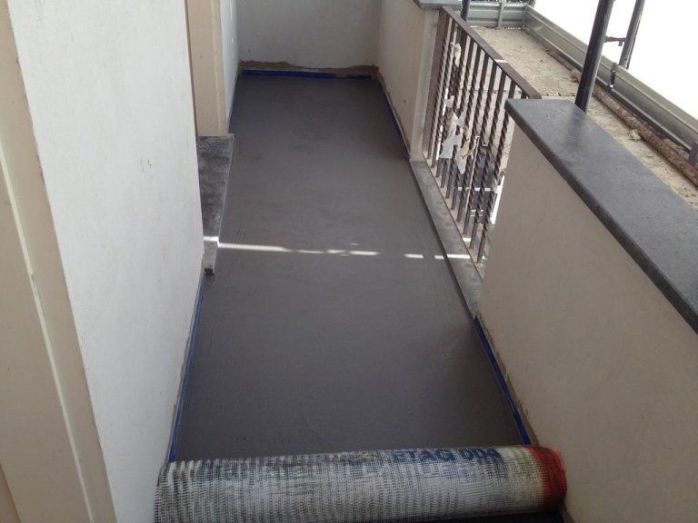 Un lungo corridoio con una ringhiera e un pavimento grigio