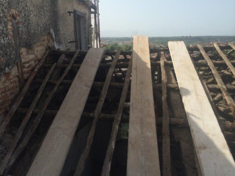 Una fila di assi di legno appoggiate sulla sommità di un tetto