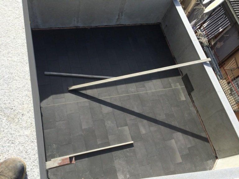 Una persona è in piedi su un balcone e guarda in basso verso una scala in costruzione