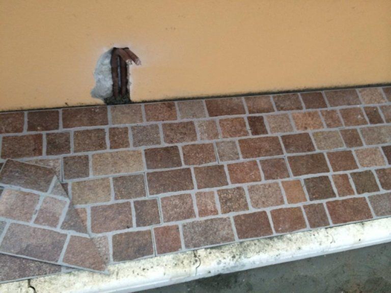 Un passaggio pedonale in mattoni con un buco nel muro