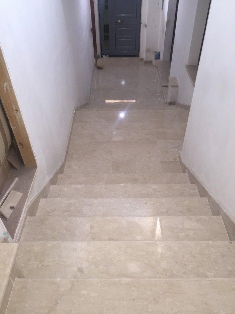 Un corridoio con scale che portano a una porta