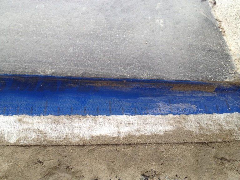 Primo piano di una linea blu e bianca su una superficie di cemento.