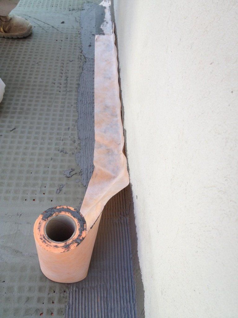 Un rotolo di carta igienica è appoggiato a terra accanto a un muro