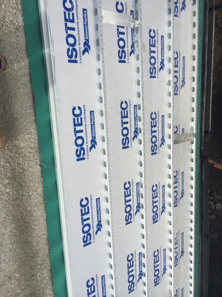 Una pila di fogli di plastica Isotec disposti uno sopra l'altro su un tavolo.
