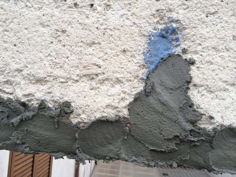 Un primo piano di un muro con una macchia blu su di esso
