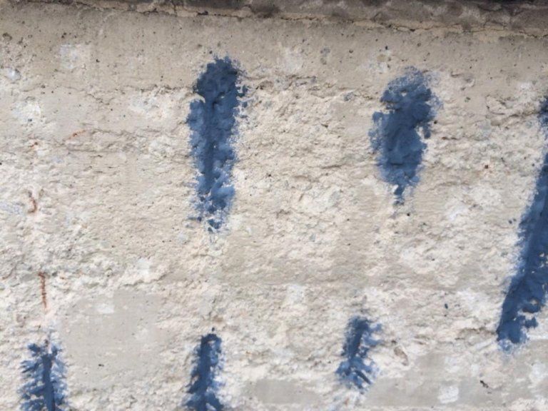 Primo piano di un muro di cemento dipinto di blu.