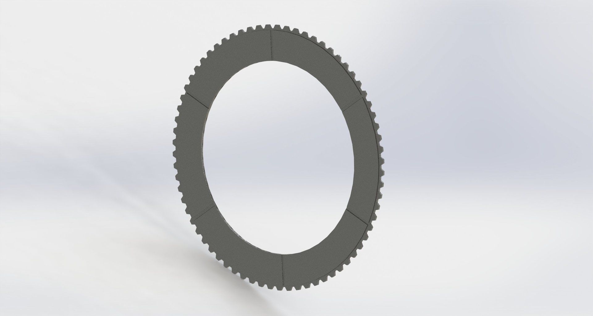 Gray, circular gear with teeth around the outside.