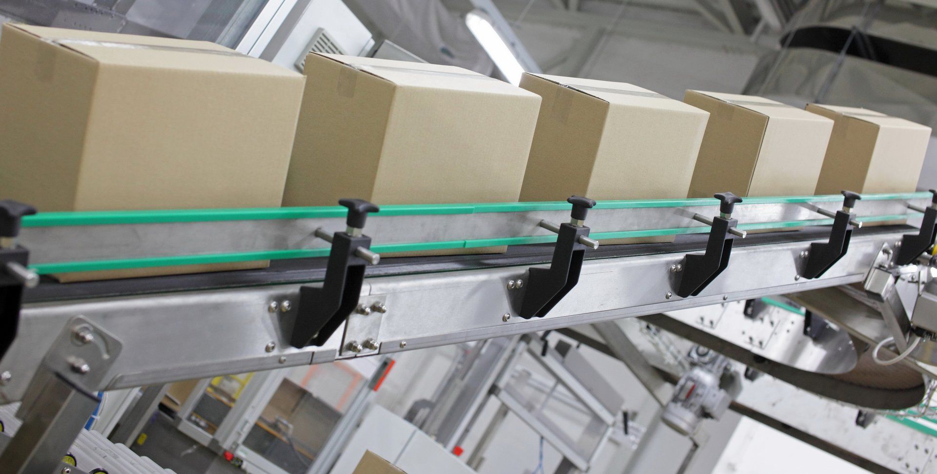 Kartons auf einem automatisierten Förderband in einer Fabrikumgebung.