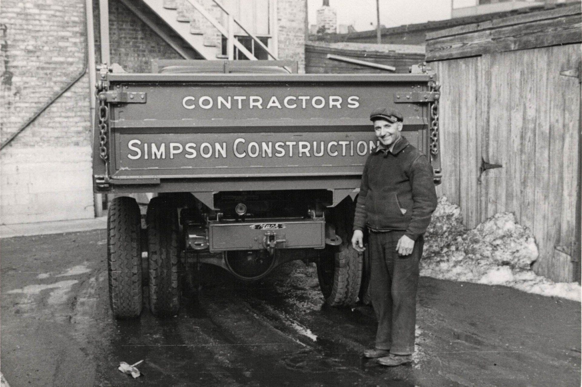 A man standing in front of a simpson construction truck