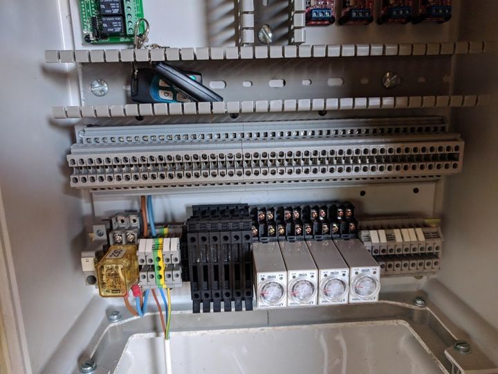 Elektrisch schakelpaneel met relais, klemmenblokken en timers.