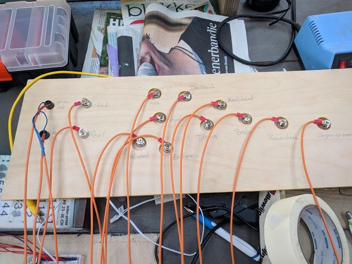 Houten plank met meerdere draden en connectoren, mogelijk voor testdoeleinden of het opzetten van een circuit.