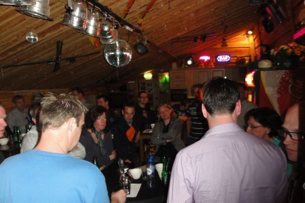 Mensen hadden zich verzameld in een schemerig verlichte bar, waar verschillende discoballen aan het plafond hingen.