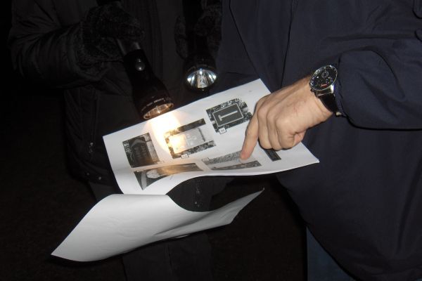 Een persoon wijst naar een document dat door een zaklamp wordt verlicht.