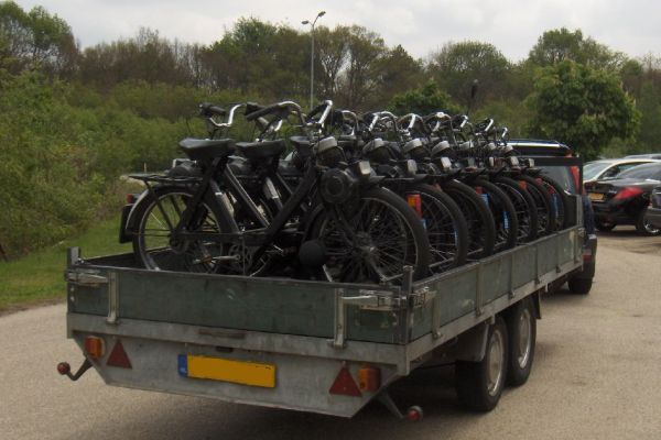 Fietsen op een aanhanger. De fietsen zijn zwart en staan ​​met de voorkant naar voren. Op de achtergrond zijn een paar auto's te zien.