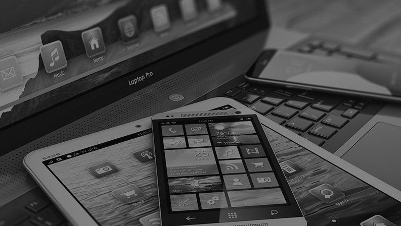 Smartphone, tablet, and laptop displaying digital apps, representing responsive web and mobile solutions.
