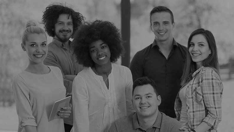 Smiling team members standing together in a workplace.