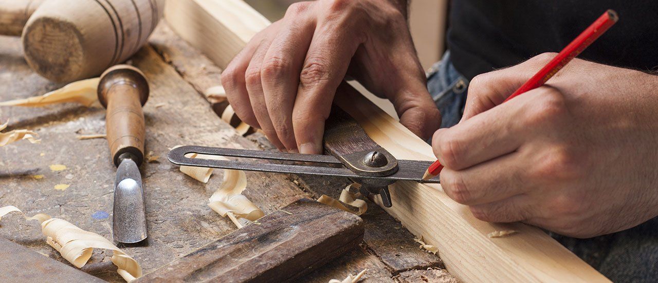 a carpenter measuring and cutting wood