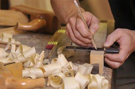 a carpenter using pencil and scale for cutting wood