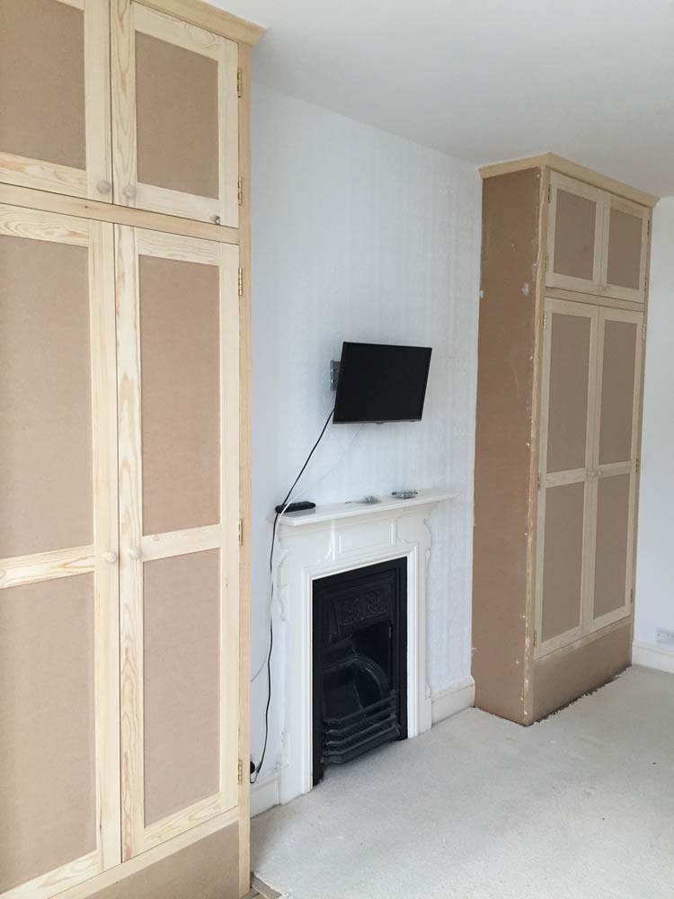 wooden cabinets fitted between wall mounted television