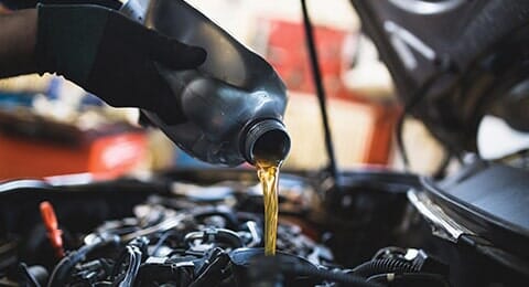 Man pouring oil - Auto repair shop in Doylestown, PA