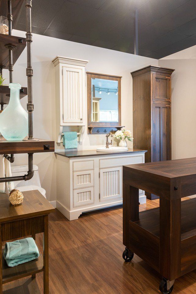 salle de bain avec armoires blanches et table marron
