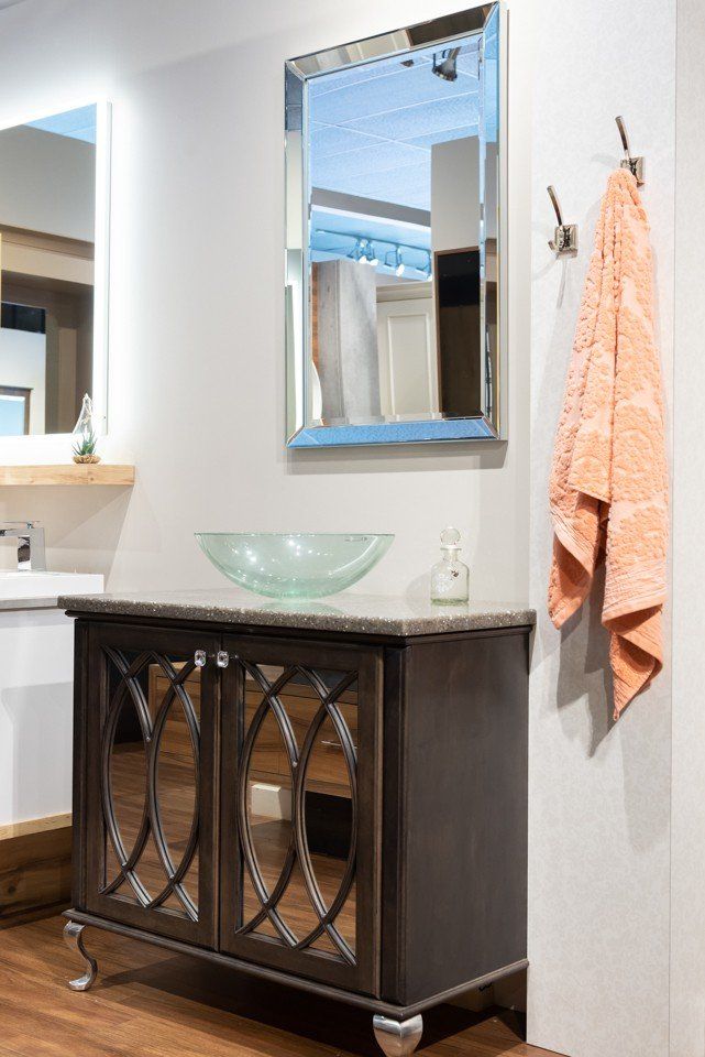 salle de bain avec armoires noires et lavabo en verre