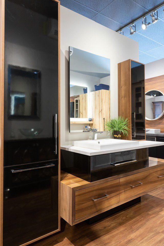 salle de bain avec armoires noires et brunes et évier blanc