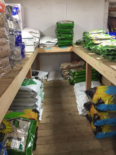 Storage room with shelves stacked with assorted bags of supplies on both sides.