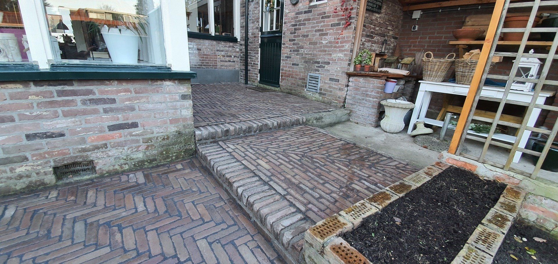 Een stenen pad en een tuin met een gebouw.