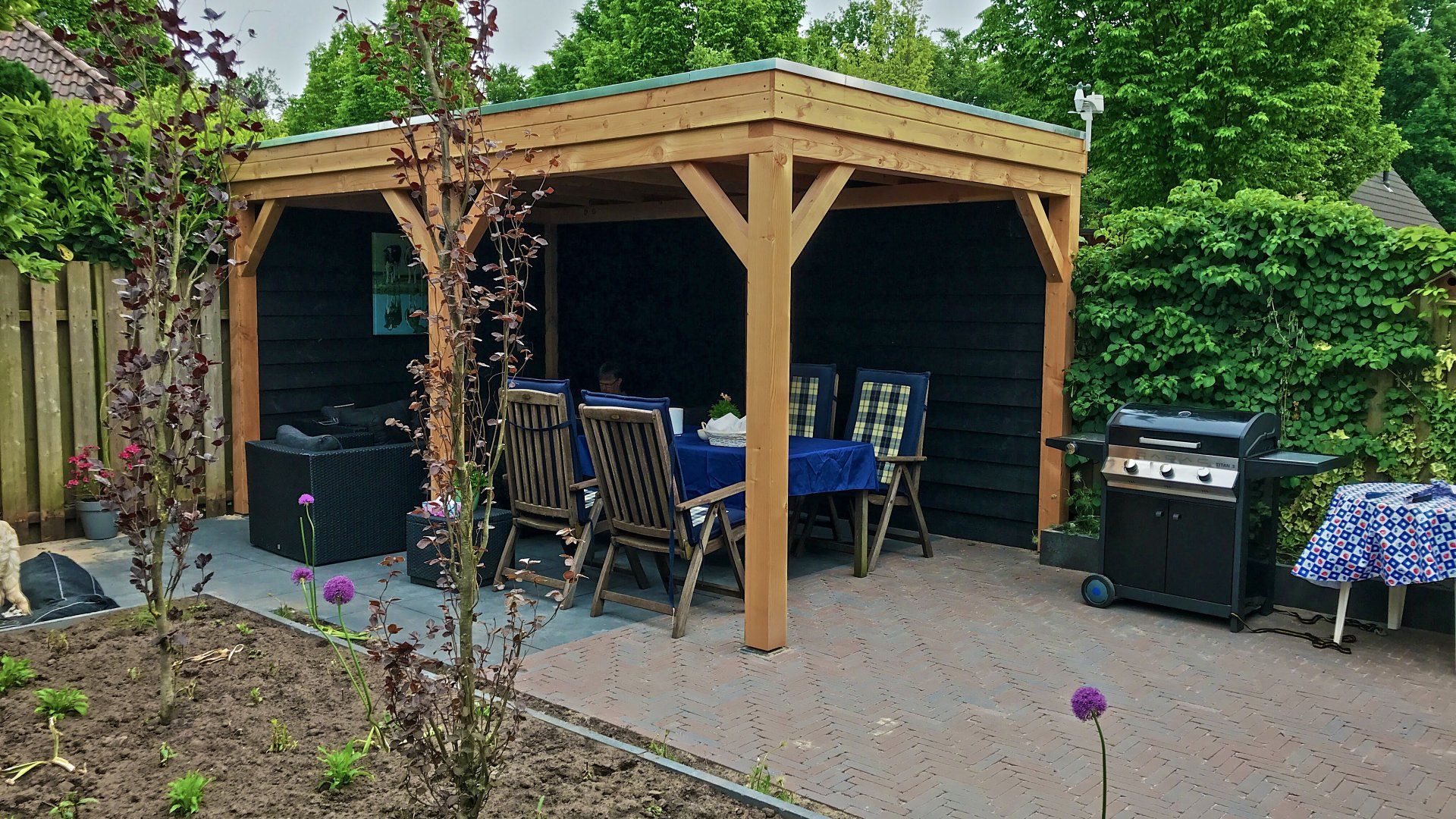 Houten pergola voor buiten met eethoek en barbecue.