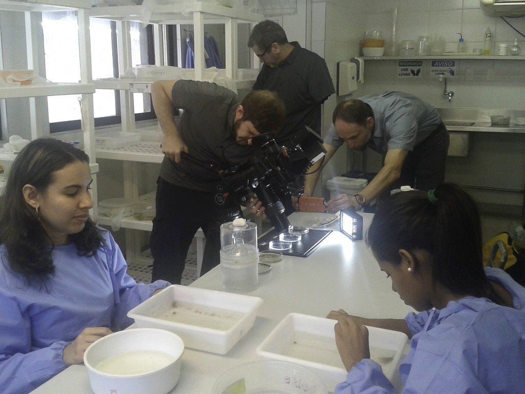 A group of people are working in a lab with a microscope