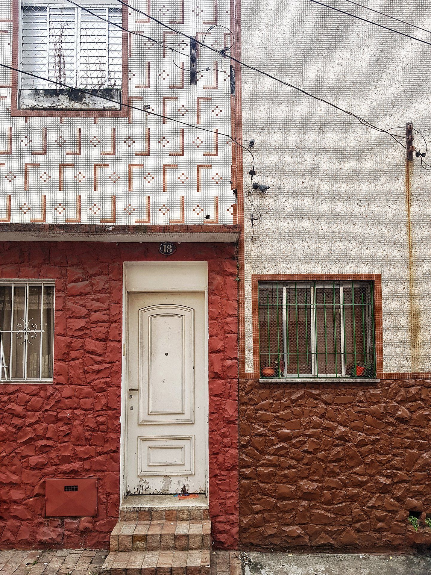 A red and white brick building with a white door and windows.