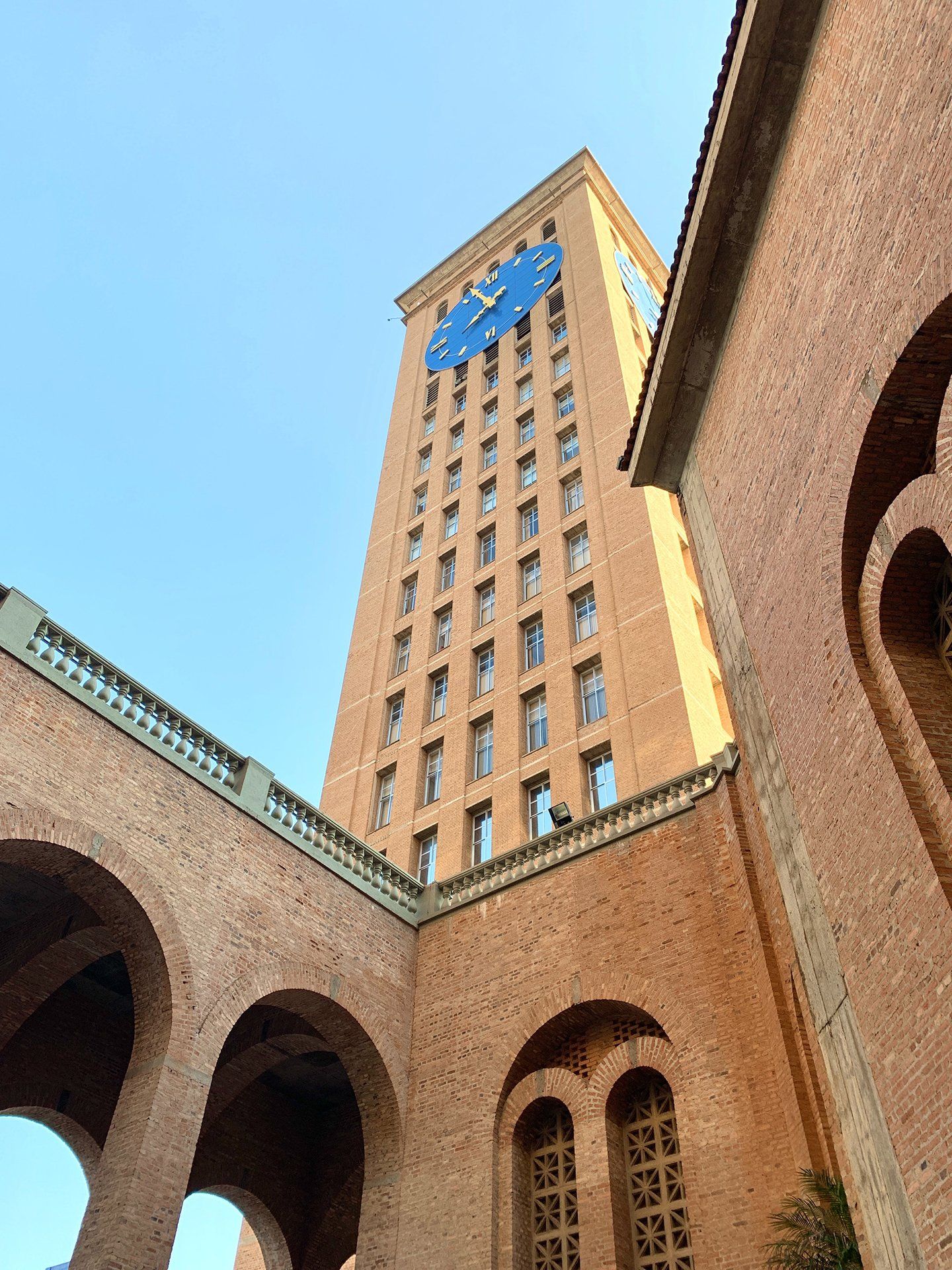 A tall brick building with arches and a clock tower.