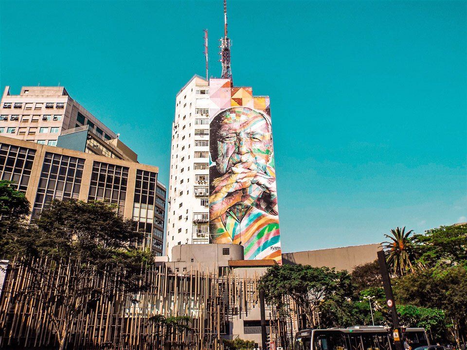 A large building with a painting of a man on the side of it.