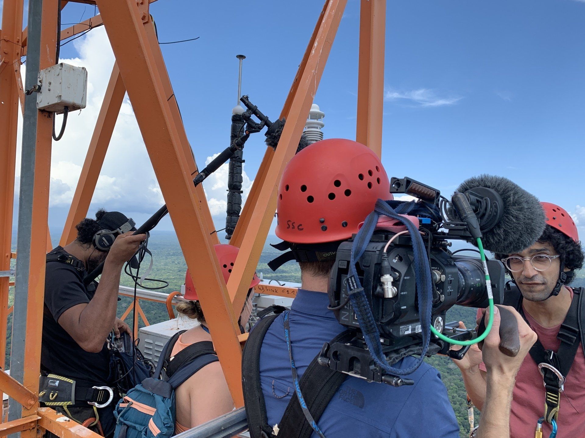 A group of people are standing on top of an orange structure.