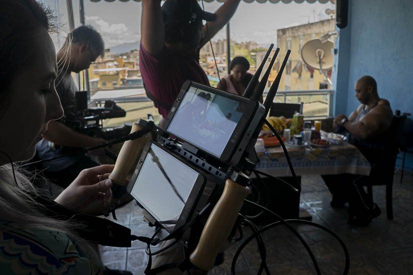 A group of people are sitting around a table looking at a screen